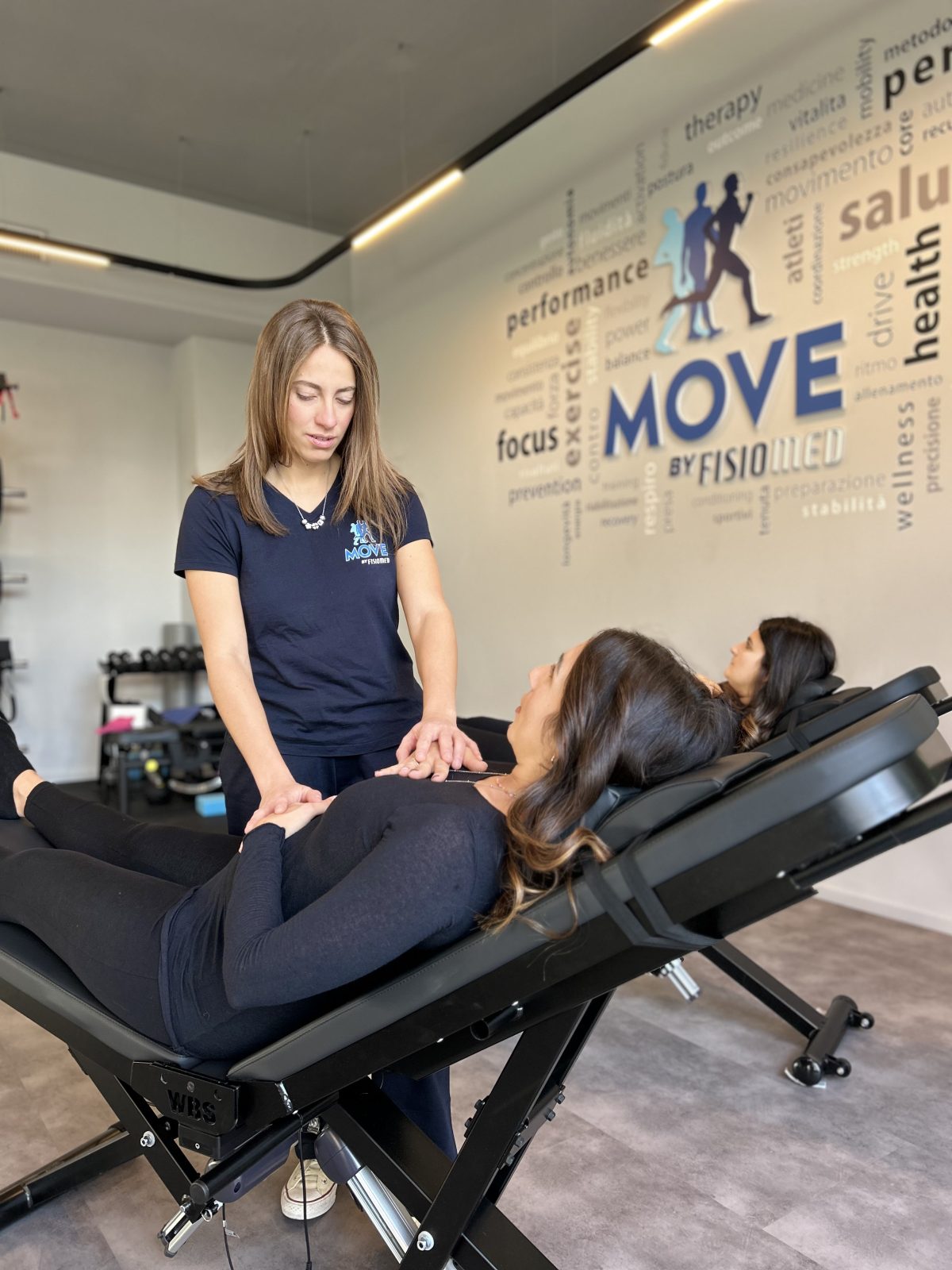 Fisioterapista segue una donna in gravidanza sulle panche WBS durante una seduta MUM in MOVE nella palestra riabilitativa MOVE by Fisiomed a Sanremo.
